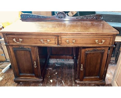 A Victorian revival mahogany pedestal sideboard/desk, scrolling foliage gallery back, slight oversailing top, over two frieze