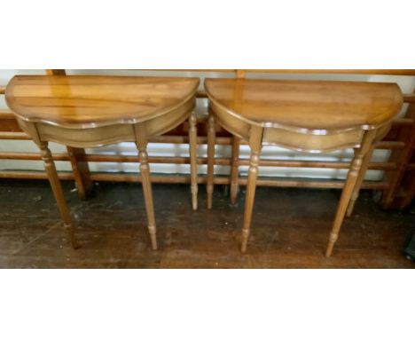 A pair of 20th century mahogany demi-lune console tables, in a Georgian style, shaped with a serpentine centre, raised on tap