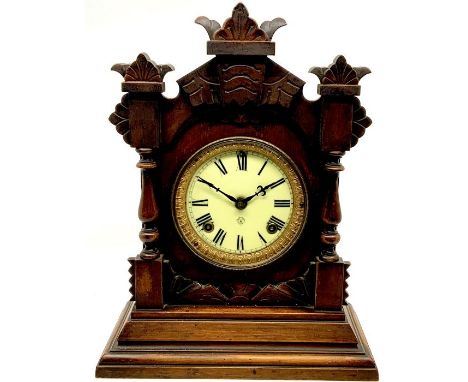 An American Ansonia clock of New York mahogany cased, arch shape carved top, 6inch brass frame enamel dial with Roman numeral