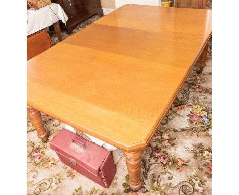 A Victorian oak canted rectangular extending dining table, raised on turned legs on brass casters. 74cm H x 140cm W x 118cm D