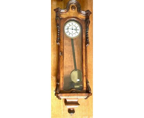 A 19th Century walnut Viennese wall clock, in a Dachluhr manner, moulded arch top, above a glazed panel door displaying a 19c