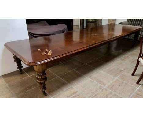 A large Victorian revival mahogany dining table, moulded curved edge top, pull out extending movement, raised on bulbous turn