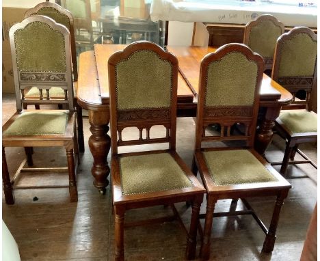 A Victorian revival oak extending dining table with extra leaves, winding movement with curved edge top, raised on turning ba