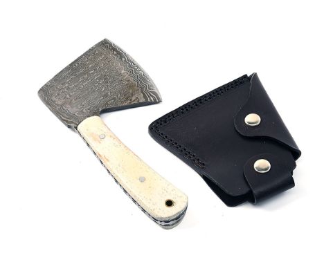 AN UNUSED DAMASCUS HATCHET, measuring 4in. from butt to bit, integral tang, mammoth grip scales, lanyard hole, with leather h