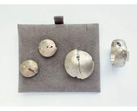A contemporary brushed white-metal jewellery set of the same Modernist design, comprising ring, slider pendant, and stud earr