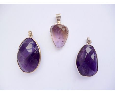 Three contemporary white-metal mounted faceted gemstone pendants, including two amethyst drops and one fluorite pendant, stam