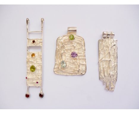 Three contemporary white-metal and gemstone pendants, each of geometric form with raised curvilinear decoration and bezel set