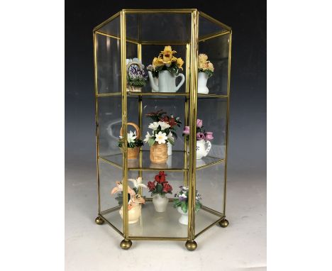 A glazed display case of miniature ceramic flowers, 26 cm