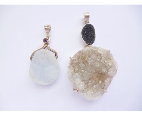 Two contemporary silver-mounted druzy gemstone pendants, one of ocean jasper, the other of blue chalcedony beneath an amethys