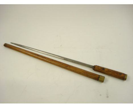 An early 20th century short sword:, the double edged blade with  brass mounted  teak handle and scabbard, 57 cm long.