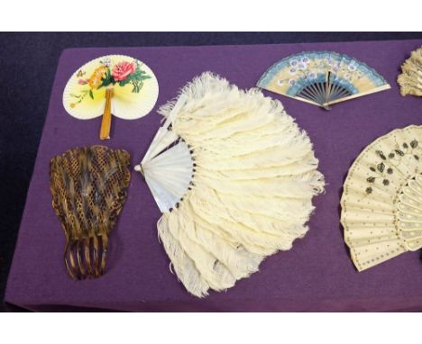 A late 19th century ivory and embroidered fan together with  two white ostrich feather fans, a large celluloid comb and eleve