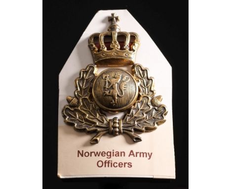 A Norwegian Army Officer's helmet badge:, with lion rampant within an oak wreath surmounted by a crown, embellished with red 