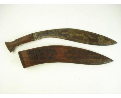 A kukri of traditional form with gilt decorated blade in carved wooden scabbard:, 50cm long..