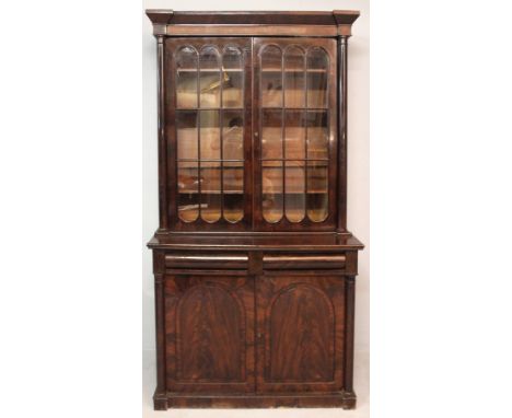 AN EARLY 19TH CENTURY MAHOGANY DISPLAY CABINET-ON-CUPBOARD, the angular pillared top incorporating astragal glazed doors with