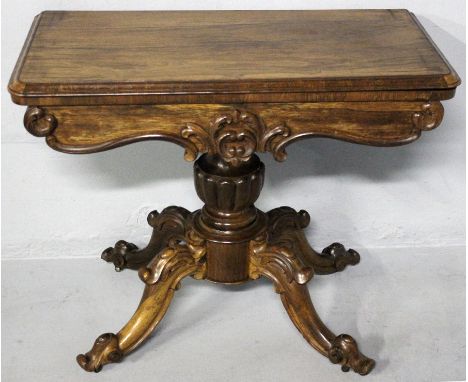 A VICTORIAN ROSEWOOD CARD TABLE, the rectangular moulded top lifting to reveal a green baize playing surface with a carved se