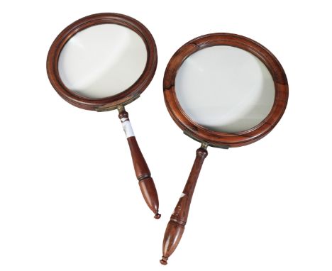 TWO LARGE VICTORIAN MAGNIFYING GLASSES both with tapering detachable turned wooden handles, the first of rosewood, 22.3cm dia