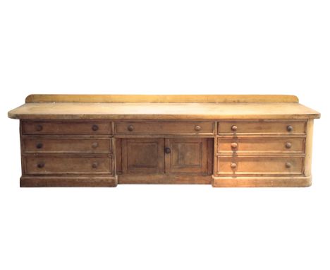 A 19TH CENTURY STRIPPED PINE HABERDASHERY COUNTERwith two plank top, fitted seven drawers and central cupboard, 85cm high x 2