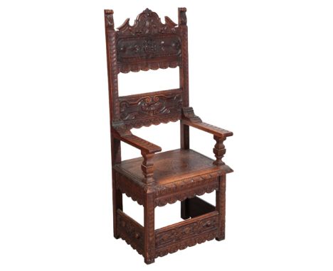 AN ITALIAN WALNUT ARMCHAIRin 17th century style, the cresting carved with a shield and floral swags, the upper back panel wit
