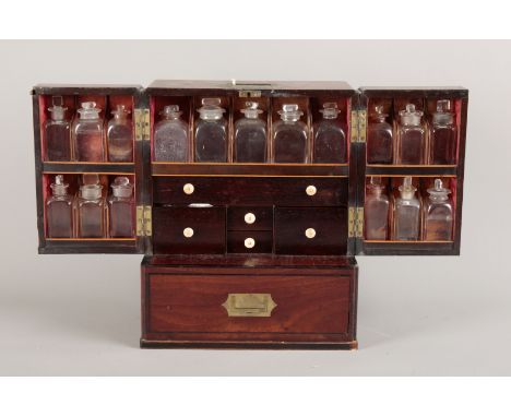 A MAHOGANY APOTHECARY CABINETearly 19th century, the double doors before sixteen glass bottles and stoppers, with an arrangem