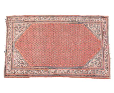 A KHOTAN STYLE RUG20th Century and artificially aged, woven in muted colours with circular medallion, floral and geometric or