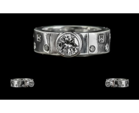 Platinum Diamond Set Band Ring, Marked to Shank. The Central Round Brilliant Cut Diamond, Flanked by 12 Small Diamonds. Est D