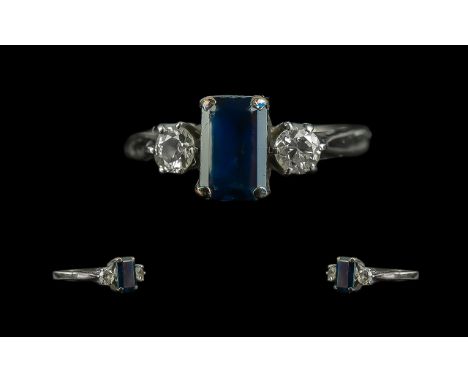 18ct Gold - Pleasing 3 Stone Sapphire and Diamond Set Dress Ring. The Central Step-cut Blue Sapphire, Flanked by Two Brillian