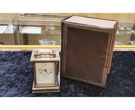 Brass Carriage Clock by Matthew Norman Clockmakers of London, architectural style, white face and Roman numerals. In box, wit
