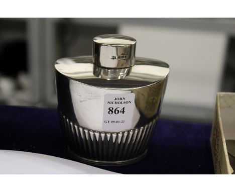 A silver oval shaped tea caddy.