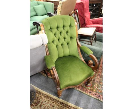 A Victorian walnut framed armchair with button upholstered back.
