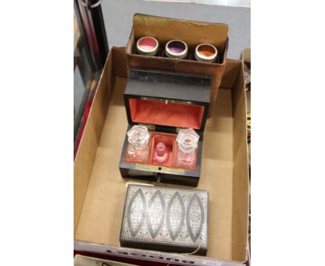 A leather cased set of three enamel top scent bottles, an ebony box containing two scent bottles and an inlaid metal box.