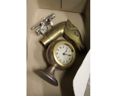 A small clock, a horse's head walking stick handle and a chrome figure.