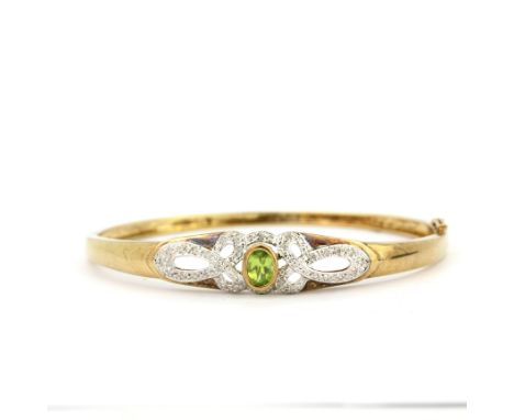 A 9ct yellow and white gold (tested) diamond and peridot set bangle, L. 6cm. Approx. 12.1gr.