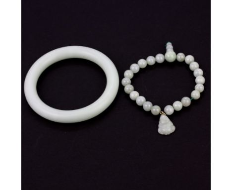 A carved and polished jade expandable bracelet together with a jade bangle, Dia. 5.6cm.
