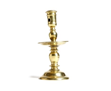 A mid-17th century Dutch brass Heemskerk candlestick, with a pierced nozzle, a turned and knopped stem and a dished drip-tray