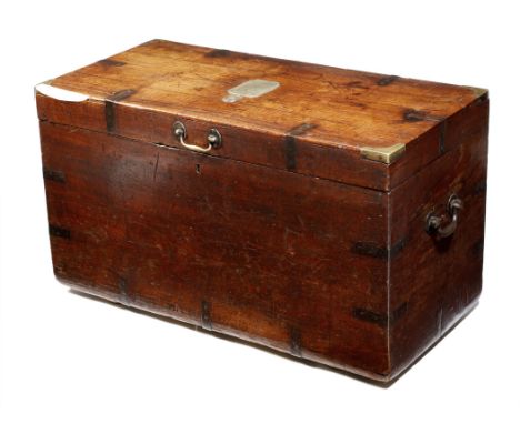 A late 18th century teak campaign trunk, with brass banding, the hinged lid centred with a brass plaque, engraved with a cres