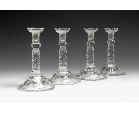 A set of four cut glass tapersticks in George III style, with scale decoration and with a knopped stem above a domed and peta