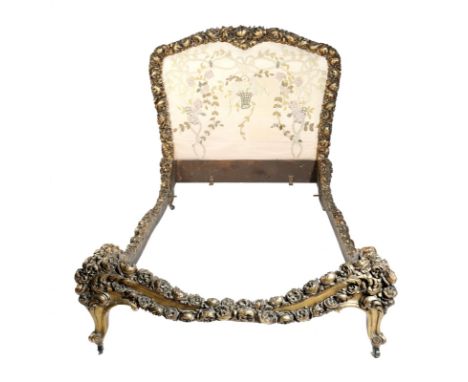 A continental giltwood bed, the frame all over carved with flowers, the headboard with a needlework panel of a basket of flow