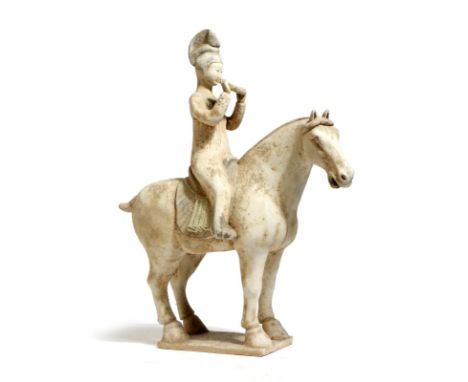 A Tang dynasty style Chinese pottery group of a horse and rider, the lady playing a paixiao, with traces of polychrome decora