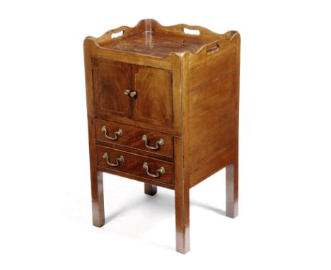 A George III mahogany tray-top bedside commode, the wavy edge gallery pierced with three handgrips, above a pair of cupboard 