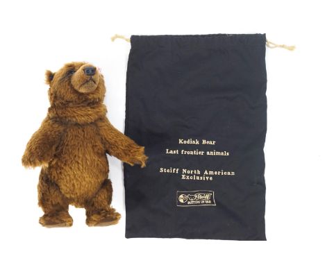 A Steiff Kodiak bear with button and label to the ear, 26cm tall, in original draw string bag