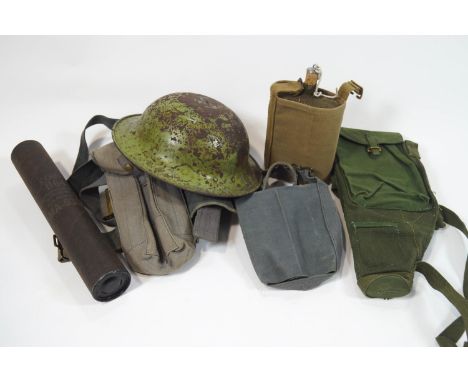 A group of assorted militaria, to include a tin hat, water flask, wooden rattle, webbing belts, gas mask filters and other it