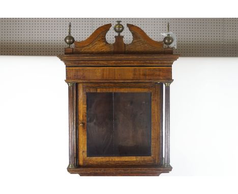 An early 19th century provincial oak long case clock case (no movement), of traditional form, the hood with a broken swan nec
