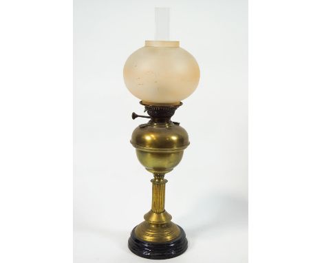 A brass oil lamp with frosted glass globular shade, 65cm high