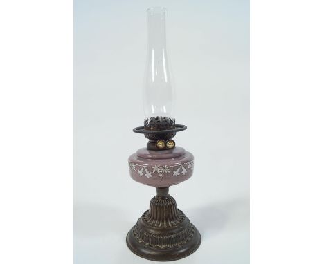 A Victorian oil lamp,the milk glass reservoir painted in white enamel with grapes and flowers, 52cm high