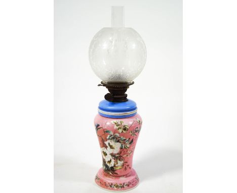 A Victorian opaline glass oil lamp, painted with flowers on a pink ground, 62cm high overall
