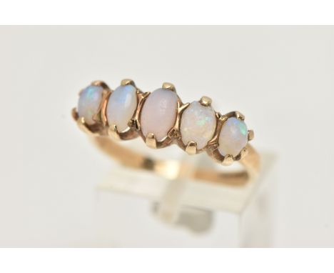 A 9CT GOLD OPAL RING, designed with a row of five oval cut opal cabochons, each in a two claw setting, to a polished band, ha