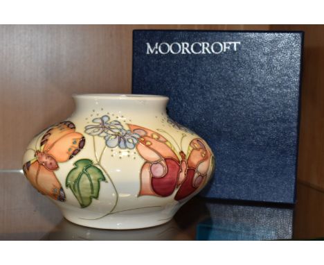 A BOXED MOORCROFT POTTERY 'BUTTERFLY' PATTERN VASE, designed by Sally Tuffin, the squat baluster vase tube lined with orange,