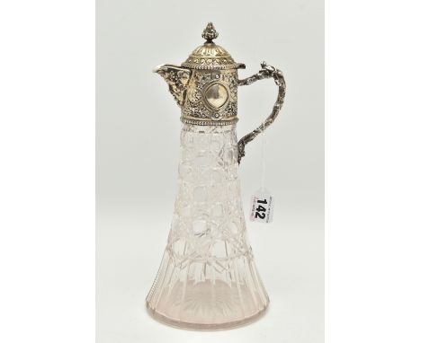 A SILVER MOUNTED GLASS CLARET JUG, cut glass tapering jug with an embossed silver mounted hinged cover featuring Baccus spout