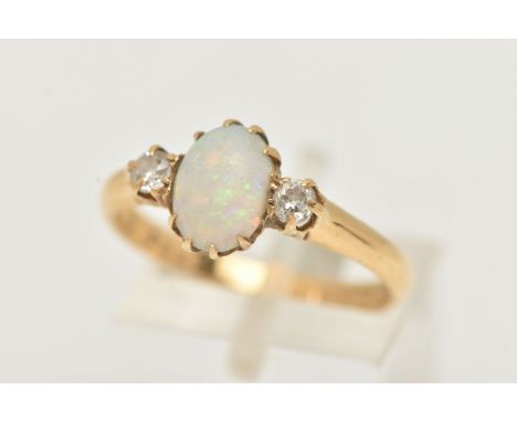 AN 18CT YELLOW GOLD, OPAL AND DIAMOND RING, designed as a central oval cut opal cabochon, claw set, flanked with two old cut 