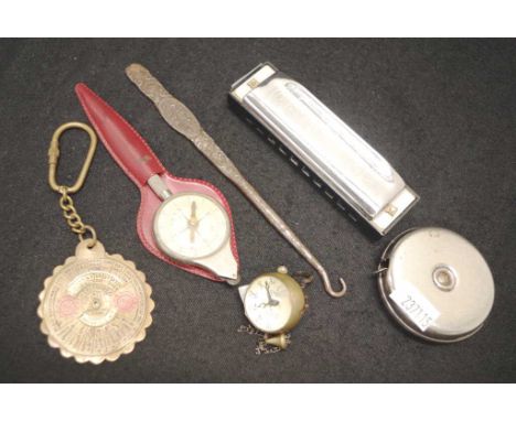 Hohner harmonica, small ball clock, tape measure, compass, button hook and keyring